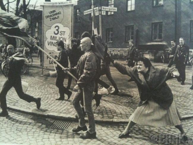 Бослогын үеэр Нацист цэргийг цүнхээрээ цохиж буй Швед эмэгтэй, 1985 он