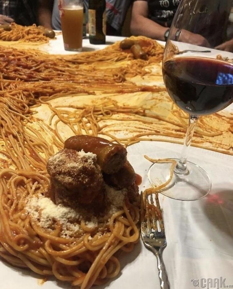 Энэ зурагт зөөгч ямар нэгэн алдаа гаргаж, ширээ дүүрэн шпагетти асгаагүй юм шүү. Зүгээр л ширээн дээр ''таваглая'' хэмээн шийдсэн нь энэ.