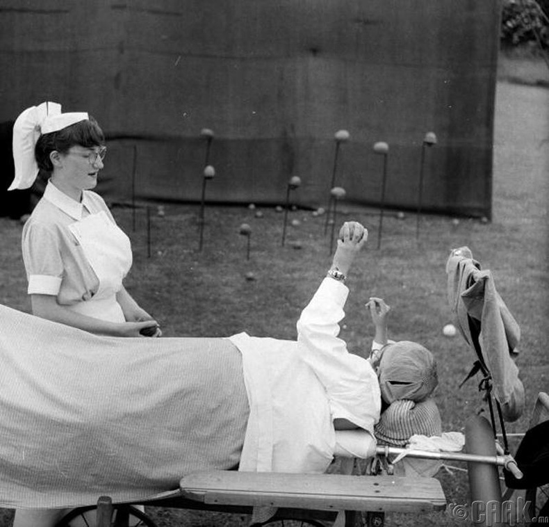 Бие нь мэдээгүй болсон өвчтөн сувилагч нарын хамт далдуу модны самар шидэж тоглож байгаа нь - 1955 он